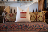 Detail of handmade vintage Aguayo weaving featuring reddish-orange and neutral tones.
