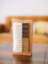Hand-woven Loom Block Art with textured cream, brown, and ochre fibers on a maple wood block.