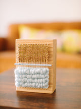 Hand-woven Loom Block Art on maple wood with textured pale blue and ochre fibers.