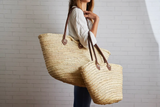 Artisan Moroccan shopping baskets, natural woven straw, authentic leather straps.