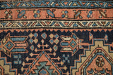 Detailed texture of a Persian Karaja rug's geometric floral border in terracotta and sky blue.
