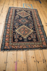 Tattered selvage and geometric border in terracotta and blue on a vintage Persian Karaja rug.