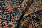 Detailed texture of a vintage Karaja rug's primitive geometric motifs in navy, gold, and terracotta.