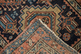 Folded corner of a vintage Karaja rug revealing the hand-knotted foundation and wool pile.