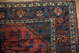 The navy blue and ivory floral border framing the corner spandrel of a fine Lilihan carpet.