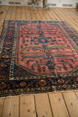 Angled perspective of a vintage Lilihan carpet showing the full tree of life design and navy blue border.