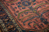 Visible hand-knotted texture with serrated leaves on a raspberry red vintage Persian Lilihan.