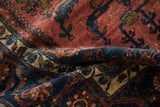 A soft fold in the vintage Lilihan carpet reveals its dense wool pile and rich navy blue patterns.