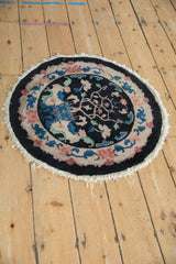 A vintage Art Deco round mat displaying its floral border and central tree of life motif.