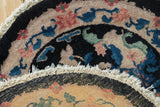 Detail showing the tattered sides and remnants of fringe on the vintage round Nichols rug.