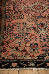 Vintage Lilihan rug's blush field with intricate floral arabesques in navy, jade, and burgundy.