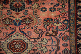 Close-up of vintage Lilihan rug pile showing playful floral arabesques in dusty rose, navy blue, and green.