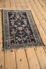 Antique Mehriban rug close-up: navy field, geometric trefoils, serrated border, worn side edge.