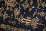 Textural details of an antique Mehriban rug, featuring geometric shapes in rich navy and subtle earth tones.