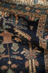 Textured fold of antique Mehriban rug, geometric plants and blossoms in navy and mauve.