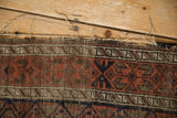 Antique Belouch rug: tattered end with visible foundation, polychromatic plain weave, geometric design.