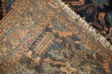 Antique Mehriban rug detail with navy and peach serrated leaf pattern, serpent border, and tattered fringe.