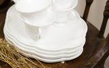 Embossed grapevine pattern on stacked white milk glass luncheon plates and cup.