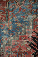 Heriz rug detail showing foundation wear, sapphire blue and blush geometric patterns.