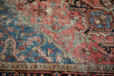 Worn blush and sapphire blue palmettes and tendrils with exposed foundation on vintage Heriz carpet.