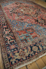 Vintage Heriz rug with navy, blush, sky blue, and jade green blossoms and tendril motifs.