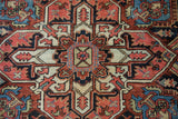 Textured pile detail of vintage Heriz carpet with geometric and stylized floral motifs in blush, navy, and gold.