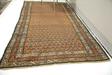 Repeating floral design and traditional border of a rusty red Mir Serbend vintage rug.
