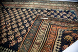 Kurdish Bijar rug turned corner, geometric laleh abassi border and dark blue Mir field.
