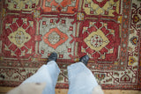 A personal view of the vintage Oushak carpet's texture and repeating paneled floral design.
