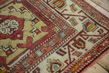 Close-up of the geometric border and textured wool pile on a vintage Turkish Oushak carpet.