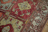 Close-up of the vintage Oushak's hand-knotted pile and geometric floral motifs.