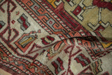 Textured low pile of a vintage Oushak rug with geometric designs in time-softened red, orange, and saffron.