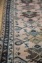 Vintage Hamadan runner's dark navy border alongside dusty blush floral palmette field.