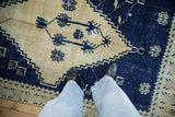 Low-pile, distressed texture of a vintage Oushak rug in dark cobalt blue and pale gold.