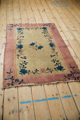 Corner of vintage Nichols Art Deco rug, with dusty pink border and delicate floral vinery.