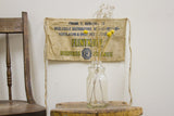 Vintage Flintkote apron styled as rustic wall decor, showing its bold blue and yellow typography.