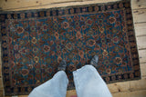 Distressed vintage Hamadan rug, abrashed blue ground with terracotta Herati motif, with feet.