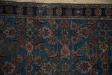 Distressed vintage Hamadan rug detail, showing navy border and Herati pattern on an abrashed blue field.