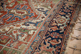Vintage Heriz carpet featuring geometric blossoms, serrated leaves, sky blue abrashes, and tattered fringe.