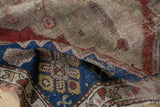 Antique Caucasian rug's visible foundation, worn pile, and indigo blue, cherry red geometrics.