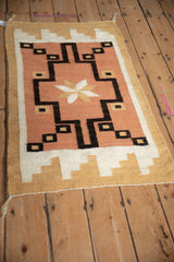 Handwoven Southwestern Navajo wool shows finned end stepped motif in dusty coral.