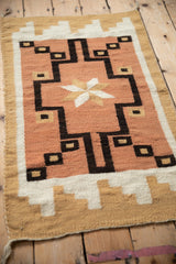 Southwestern hand-woven rug with finned end stepped motif in dusty peach, ivory, and beige.