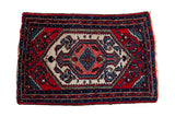 A vintage Persian Hamadan rug mat with a geometric medallion in cherry red, sapphire blue, and ivory.