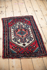 Overhead angled view of a vintage Hamadan rug, showing its concentric medallion and detailed borders.