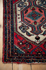 Textured corner of a vintage Hamadan rug with sapphire blue and cherry red vine borders.