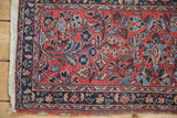 Close-up of the vintage Lilihan rug's navy floral border and its plain weave side finish.