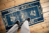 Worn cobalt blue field of antique Peking rug, revealing foundation and dusty floral sprays.