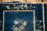 Antique Peking rug: cobalt blue field, beige floral border, and visible foundation wear.