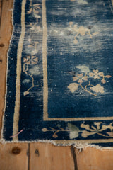 Antique Peking rug corner detail: cobalt blue field, beige border, visible foundation wear.