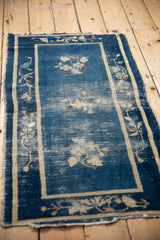 Worn cobalt blue field of a late 1910s Peking rug, revealing beige floral sprays and foundation.